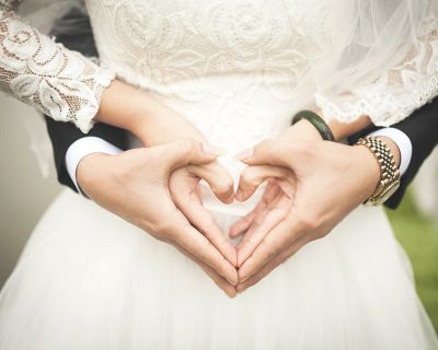 Bride and groom making the shape of a heart with their hands