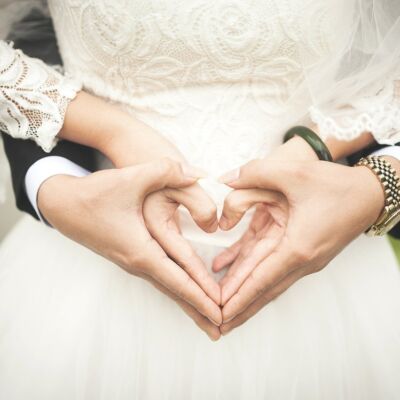 Bride and groom making the shape of a heart with their hands