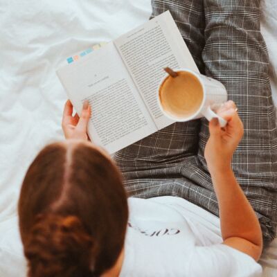 Woman reading a book and drinking coffee
