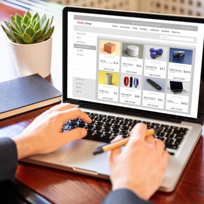 Online shop website developer working with a laptop, office desk background.